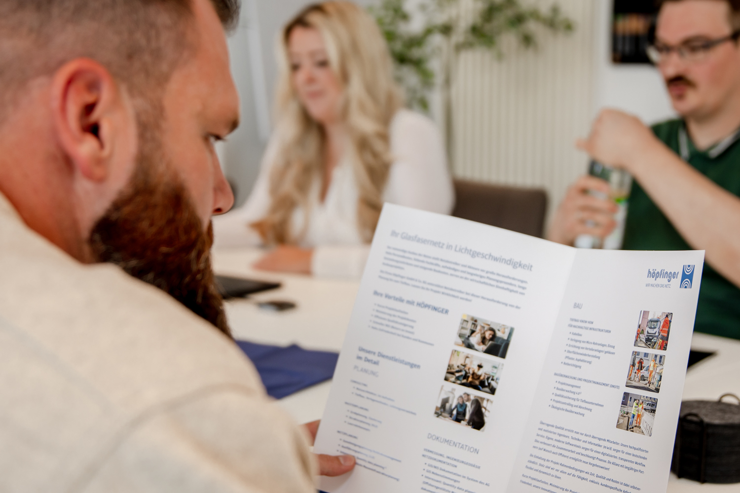 Höpfinger Mitarbeiter liest das Firmenprospekt
